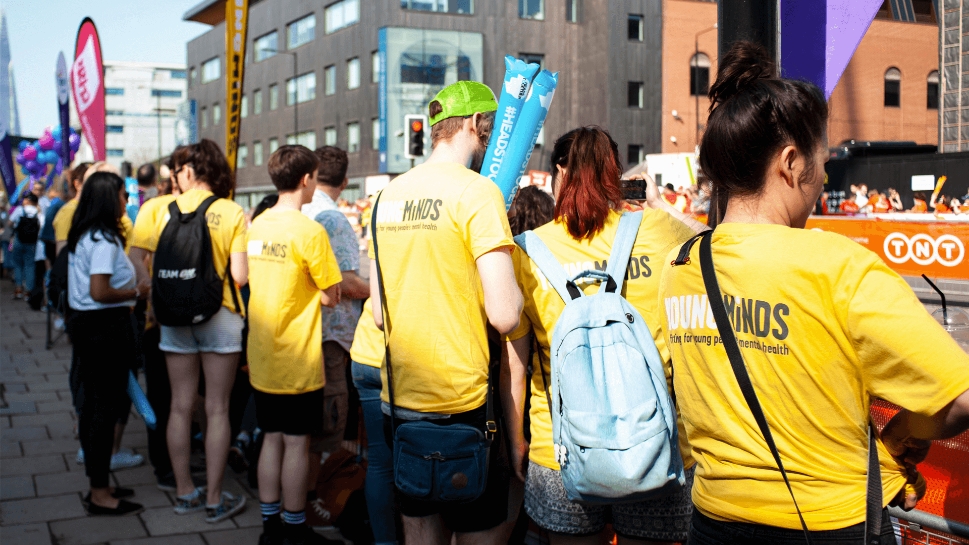 group pf YoungMinds volunteers wear YoungMinds shirt as they cheer for runners in the marathon