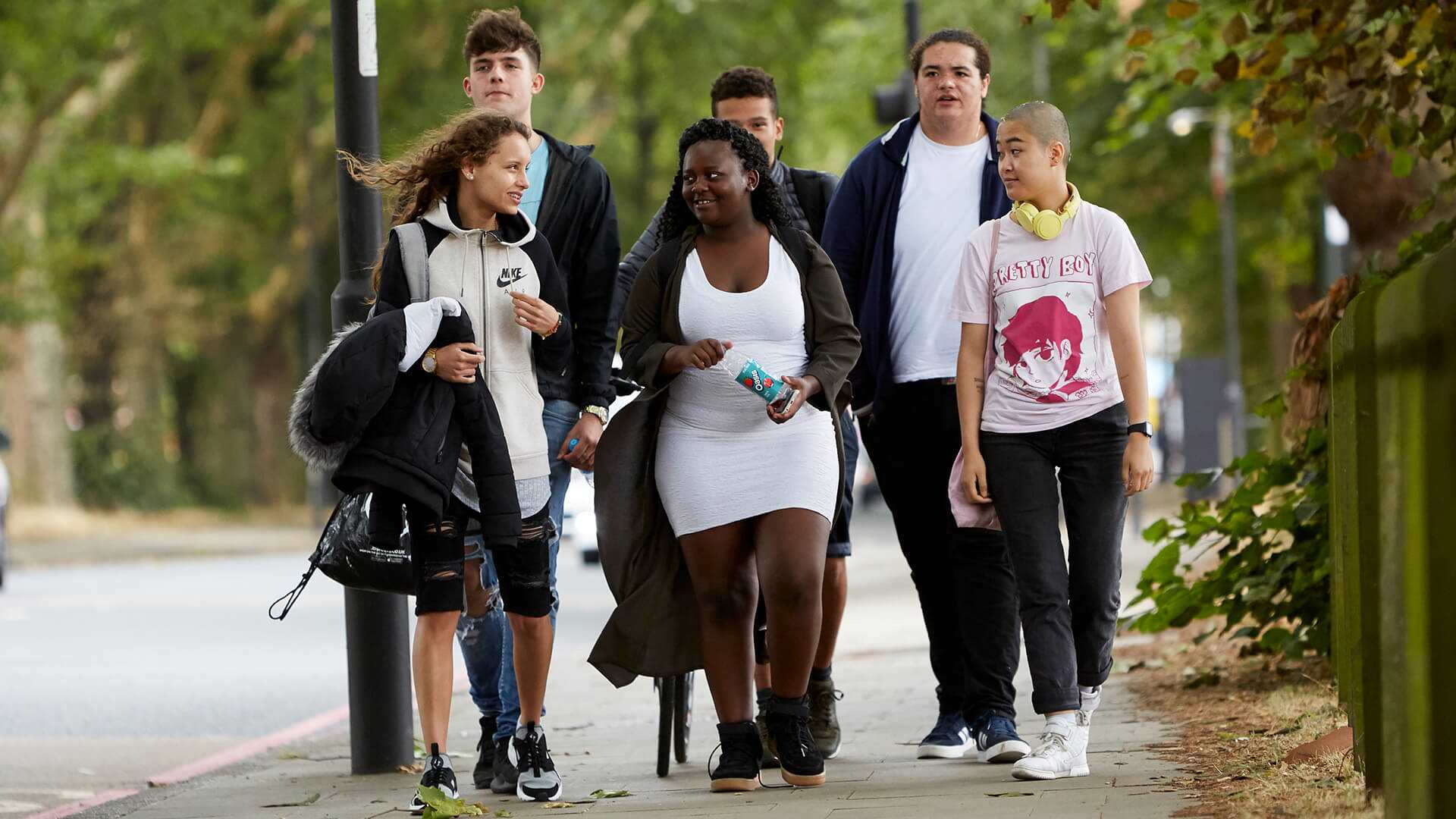 six-young-people-chatting-while-walking-in-a-park.