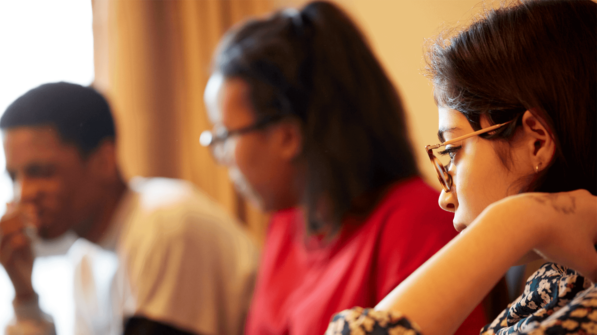 close-up-of-a-mixed-group-of-young-people-looking-at-different-directions-while-sitting-in-a-room