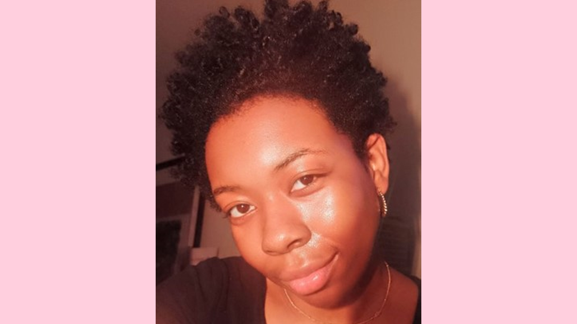 Neka is looking at the camera wearing a necklace and a black tshirt.