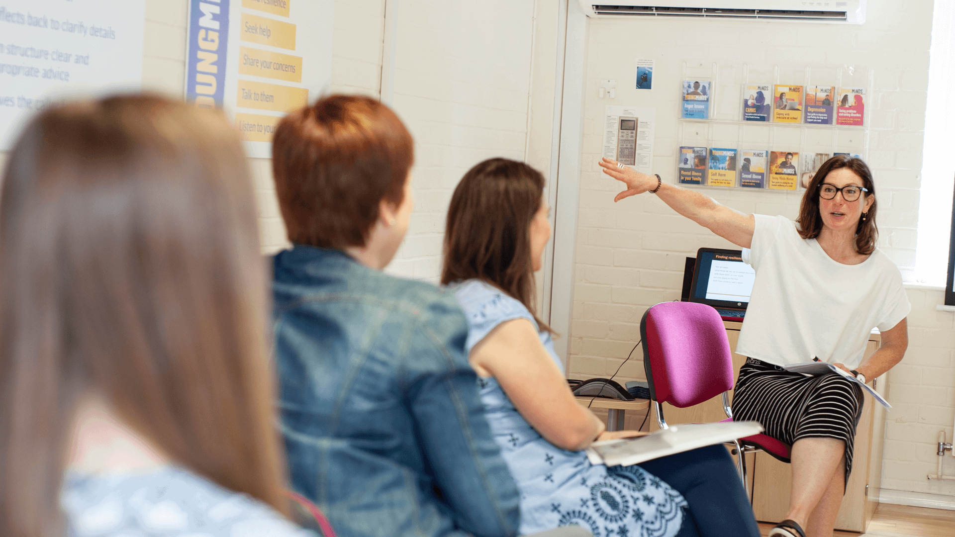 facilitator gives lecture to a group of parents for a training course