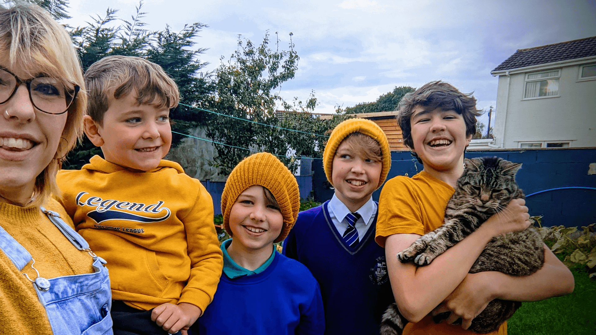 A family of five all stand together smiling wearing yellow outfits, hats and t-shirts to support #HelloYellow