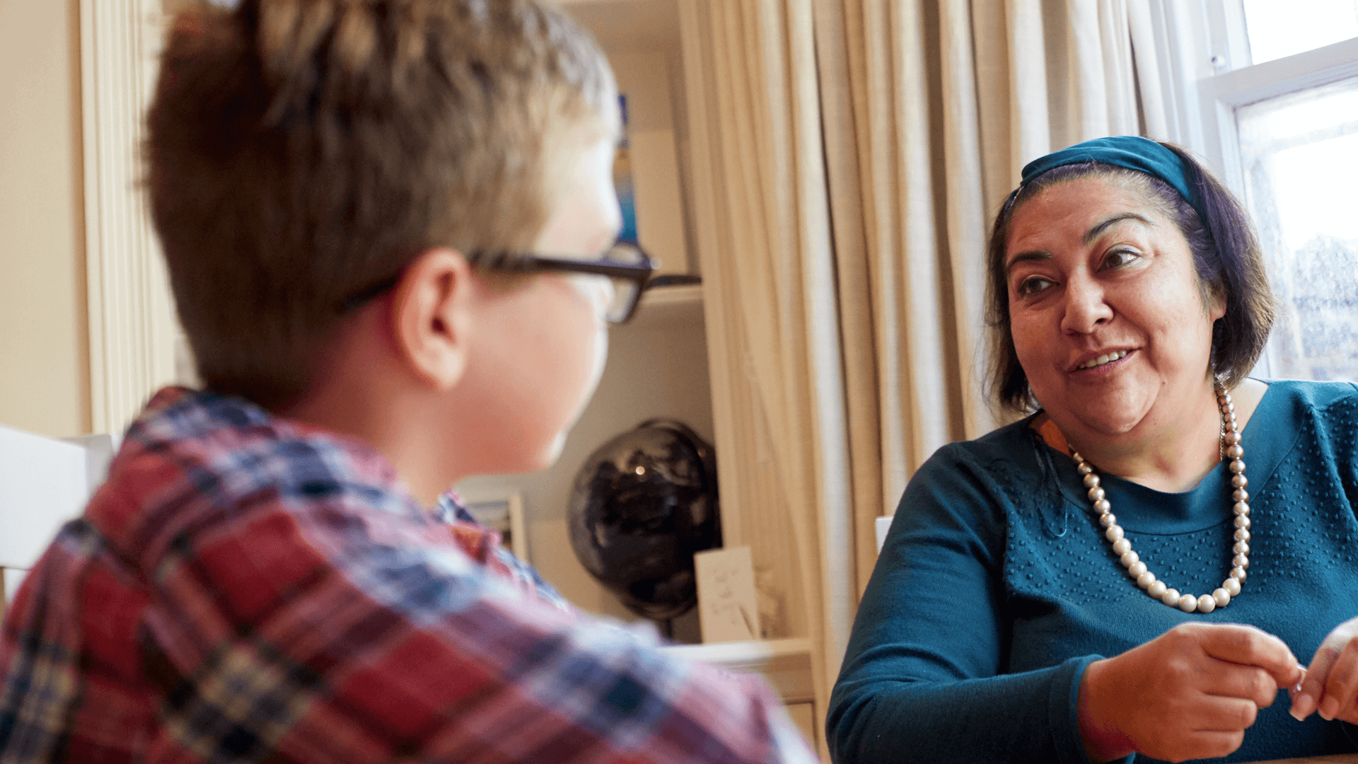 A lady talking to a young boy with a smile on her face