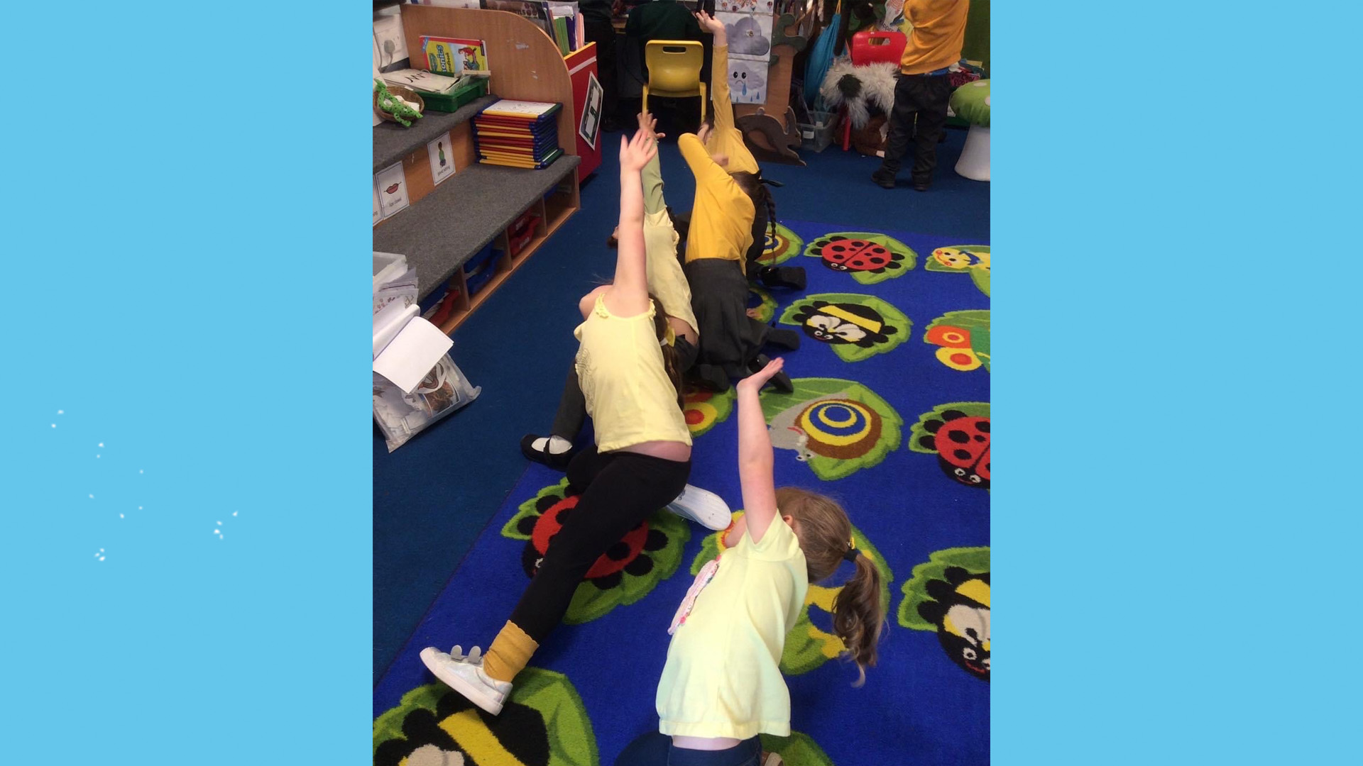 Three children doing yoga in school, all wearing yellow.