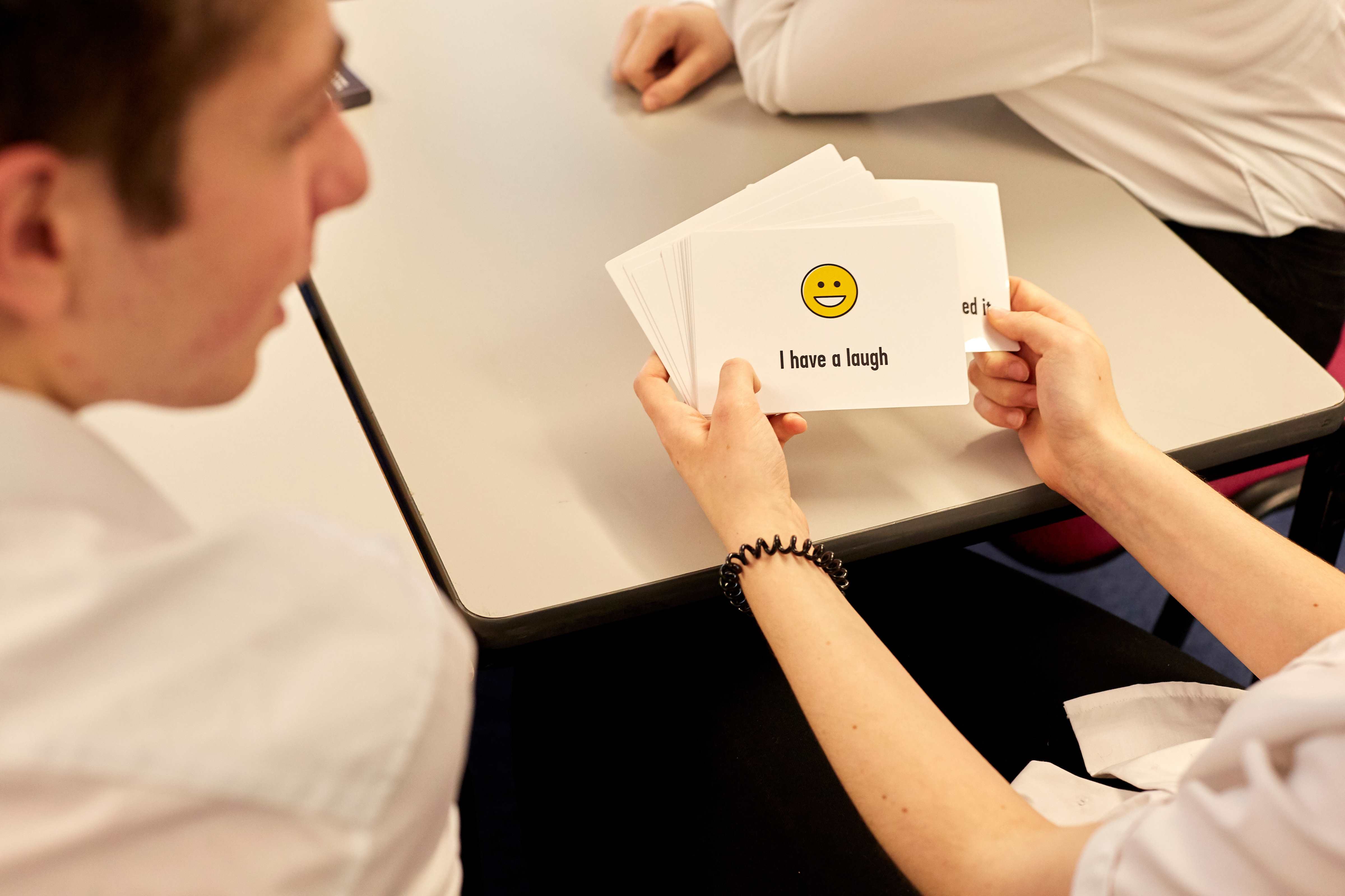 close up of hands holding YoungMinds secondary resilience cards secondary pack